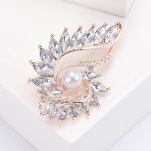 Elegant rose gold brooch with white pearl and marquise crystal on a white display stand