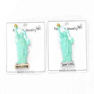 Vue détaillée des broches Statue de la Liberté en finitions dorée et argentée New York