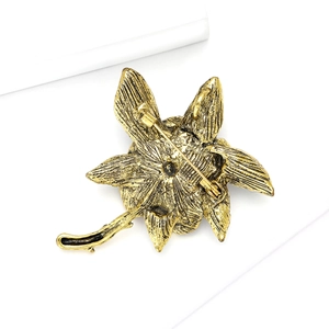 Detailed back view of vintage gold flower brooch showing the secure metal pin fastener