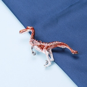 Detail of cute orange enamel dinosaur brooch with realistic textures on a blue background
