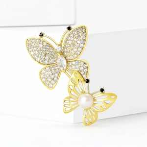 Elegant double butterfly brooch with sparkling white zircons, pearls, and gold openwork