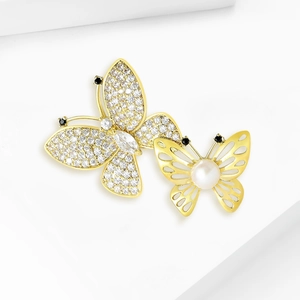 Fashionable butterfly brooch set with rhinestones and white pearl on white geometric stands