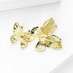 Close-up of the hollowed honeycomb texture and pin clasp on a golden butterfly brooch