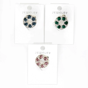 Detailed macro view of crystal wreath brooches in blue, green, and pink on display card