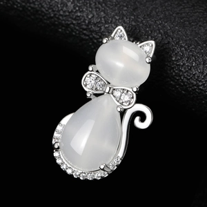 Gros plan détaillé d'une broche chat en argent avec pierres œil-de-chat et cristaux blancs