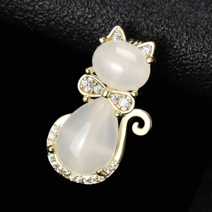 Vue macro d'une broche chat dorée avec pierres opalescentes et zircons brillants détaillés