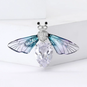 Exquisite bee brooch with pear-shaped cubic zirconia and blue gradient wings on white stand