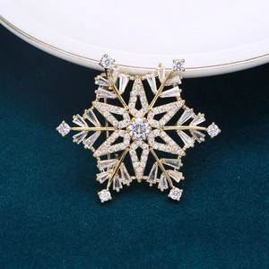 Close-up of golden snowflake brooch with sparkling cubic zirconia on dark velvet