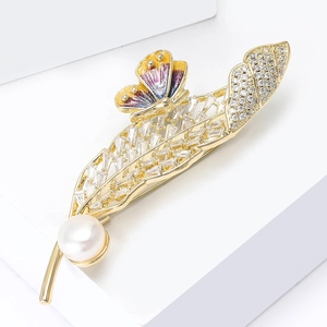 Détail de la broche feuille dorée avec zircons, perle blanche et papillon en émail