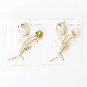 Détail de broches tulipes en nacre avec perles dorées et blanches sur carte support