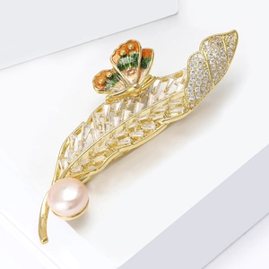 Détails de la broche plume dorée avec papillon en émail et décoration de perles