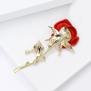 Broche rose dorée élégante avec pétales en émail rouge et zircons sur un support blanc