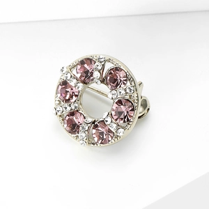 Detail of silver round brooch with purple rhinestones and clear zircon accents