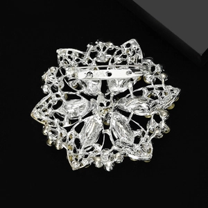 Exquisite silver flower brooch with intricate hollow metal design and secure back pin