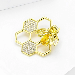 Sparkling gold honey bee and honeycomb brooch with yellow gemstones and white crystals