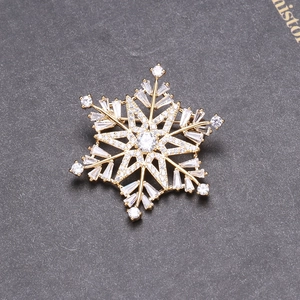 Detailed close-up of a 3D snowflake brooch with gold finish and sparkling zircon stones