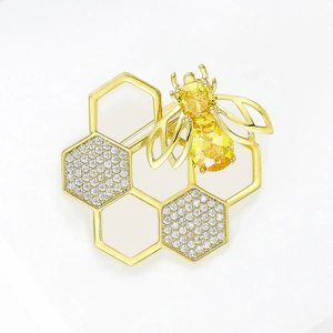 Elegant gold bee and honeycomb brooch with sparkling yellow gemstones and white rhinestones