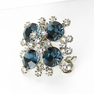 Dettaglio della spilla placcata rodio con cristalli blu navy e brillanti diamanti bianchi