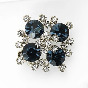 Dettaglio di una raffinata spilla di strass con pietre grigio scuro e placcatura in argento