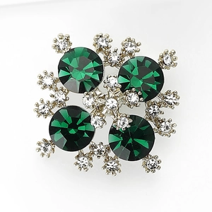 Dettaglio della spilla a fiocco di neve con pietre verde smeraldo e strass scintillanti