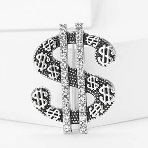 Detail of silver dollar sign brooch with sparkling rhinestones and textured finish