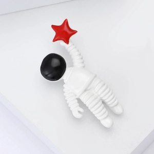 Creative astronaut enamel brooch holding a red star on minimalist white background