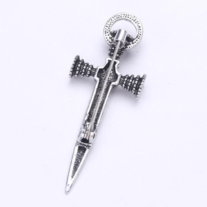 Close-up of vintage silver sword brooch with detailed hilt and secure pin clasp closure