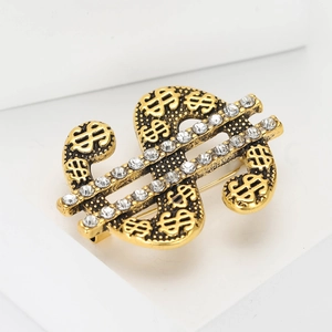 Hip hop style gold dollar sign brooch with white rhinestones on a minimalist background