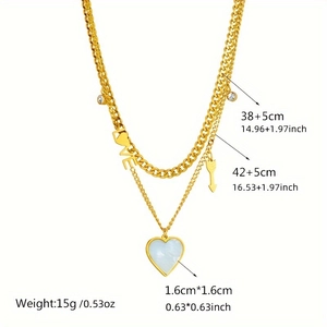Detailed view of layered gold necklace with LOVE pendant, heart shell, and chain specs