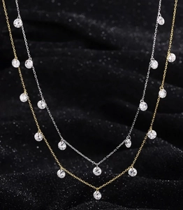 Détail de colliers gouttes d'argent et d'or avec cristaux de zircone scintillants