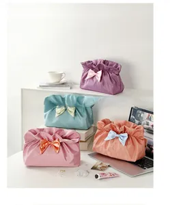 Detailed view of large capacity makeup bags with satin bows and drawstring closures
