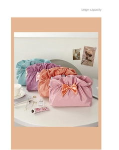 Detailed view of assorted satin bow cosmetic bags in various soft pastel colors