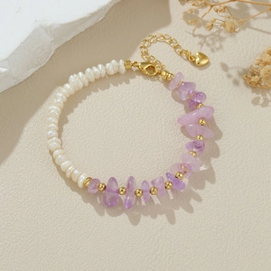 Close-up of baroque pearl and purple amethyst stone bracelet with heart pendant detail