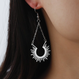 Boucles d'oreilles pendantes en acier argenté avec pendentif rayon de soleil sur mannequin