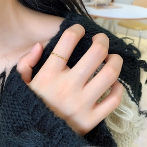 Close-up of minimalist 18K gold plated thin twisted rope ring worn on finger