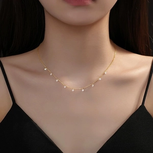 Gros plan d'un collier en argent S925 doré avec pampilles en zircone étincelantes