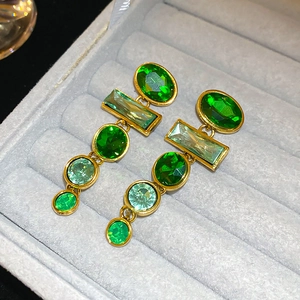Macro shot of vintage emerald drop earrings with gold metal base in a jewelry box