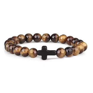 Detailed macro shot of 8mm tiger eye stone beads with a matte black cross pendant
