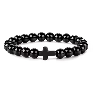 Close-up of 8mm polished black beads bracelet with a matte black cross charm detail