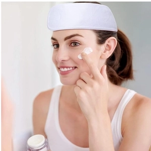Close-up of white absorbent spa headband for skincare on female model in bathroom