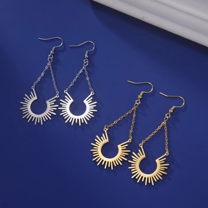 Détail de boucles d'oreilles pendantes en or et argent avec pendentif rayon de soleil