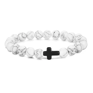 Close-up of 8mm white howlite beads with a matte black cross charm on a stretch bracelet