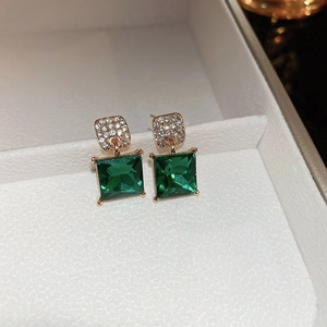 Detailed macro view of vintage emerald green square stud earrings in a white gift box