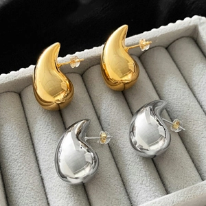 Chic gold and silver waterdrop earrings with a polished mirror finish in a jewelry box