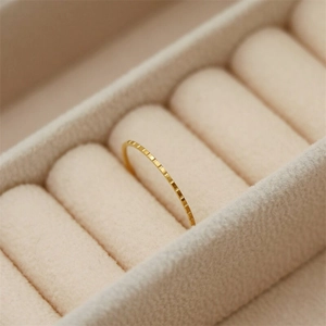 Macro shot of 18K gold plated ring featuring textured geometric pattern on a velvet box