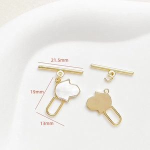 Detailed view of 18k gold plated Hamsa hand charms and OT toggle clasp with mother of pearl