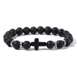 Close-up of black lava stone beads with a religious cross pendant and silver spacers