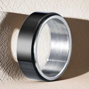Close-up detail of a black and silver 8mm stainless steel spinner ring for stress relief