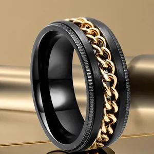 Macro detail of black titanium steel rotating ring with golden curb chain inlay