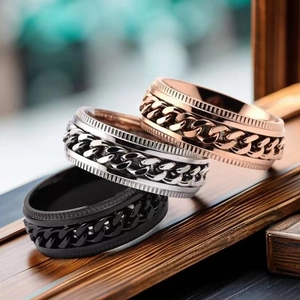 Detailed view of three rotatable chain spinner rings in rose gold, silver, and black